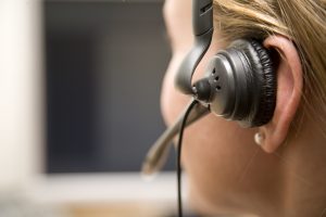 Police and EOC dispatch close up on earpiece on dispatcher.