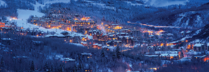 A snowy Town of Snowmass at night with lights glowing in the dusk. The town uses GIS.